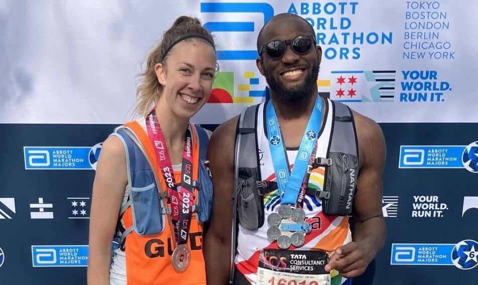 Anthony Butler and his guide wearing their London Marathon and Abbot World Major Medals at the finish of the London Marathon.